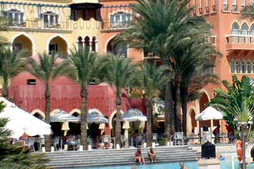 Palmen direkt vor der Fassade und Balkone zwischen dem schmalen Streifen bis zum Swimmingpool im Hotel Grand Resort in Hurghada, am Roten Meer beim Ägypten Urlaub 2011.
