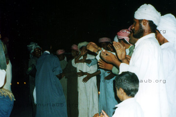 Beduinen die in der Nacht in der ägyptischen Wüste ausgelassen feiern, tanzen und trommeln.