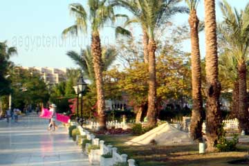 Touristen auf dem Weg von Strand in das gebuchte Resort in Hurghada. Die Luftmatratze kann man sich in Hurghada in einem Shop kaufen, die die Touristin unterm Arm trägt.