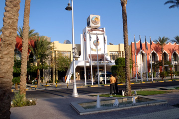 Parkplatz und ein Gebäude gegenüber vom Eingang zum Grand Hotel in Hurghada am Roten Meer beim Ägypten Urlaub.